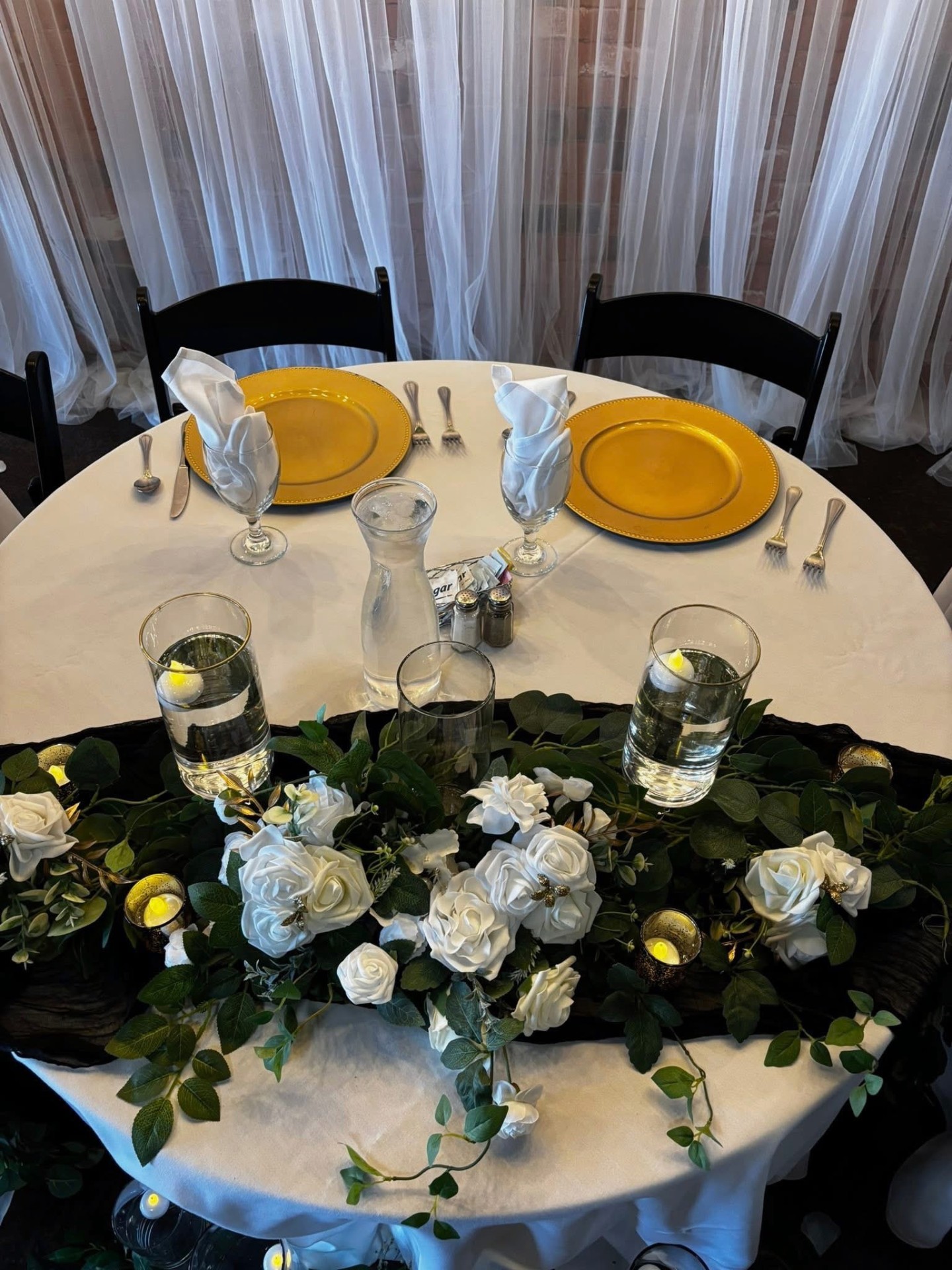 Elegant tablescape with gold accents and lush greenery centerpieces